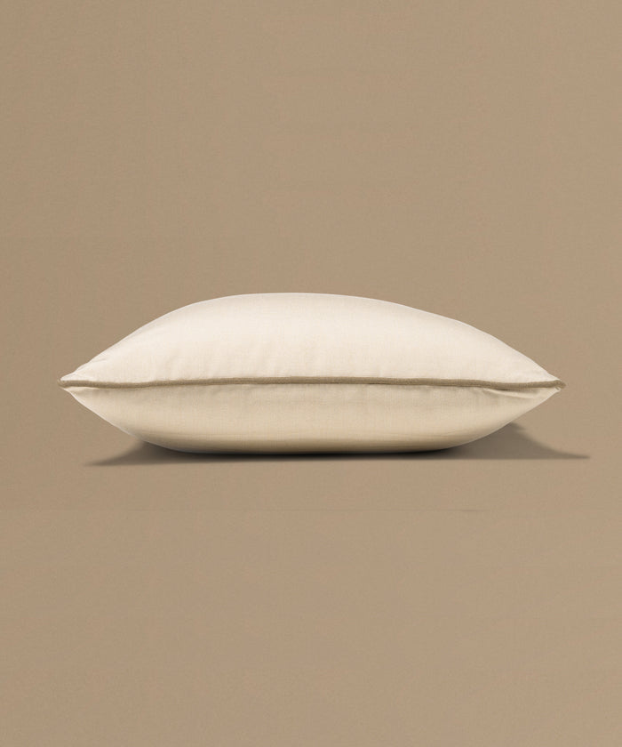 Beige pillow with a tag on a beige background