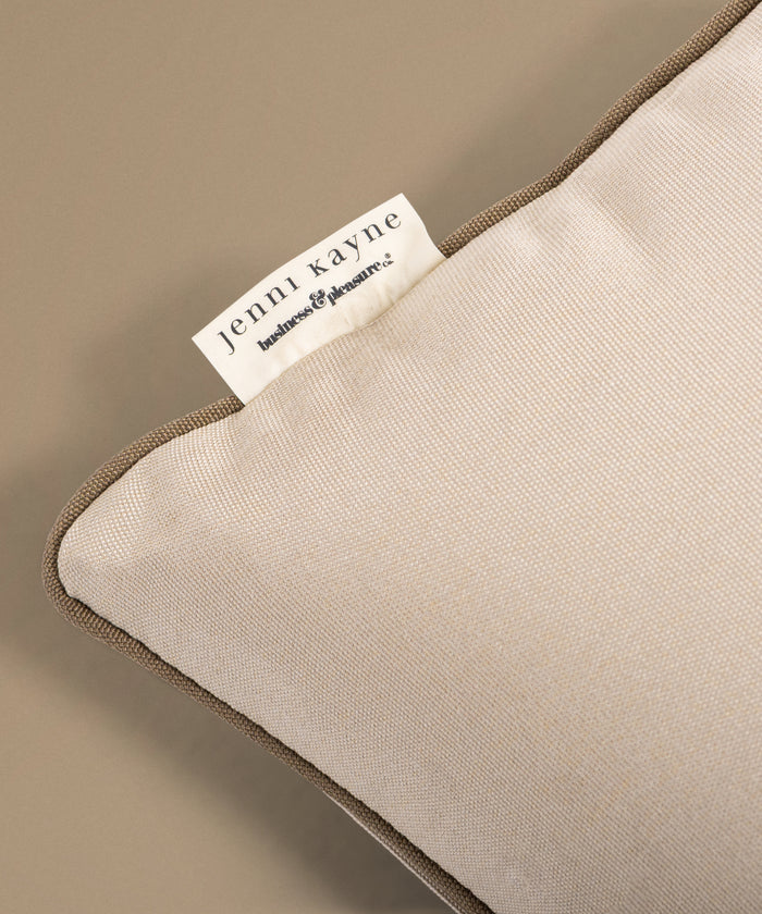 Beige pillow with a tag on a beige background