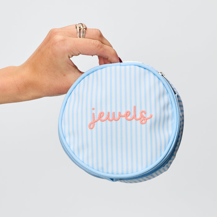 ringed hand holding the travel jewelry case in Heritage Blue Stripe